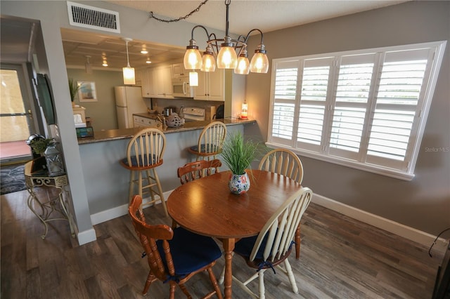 dining space with dark hardwood / wood-style flooring