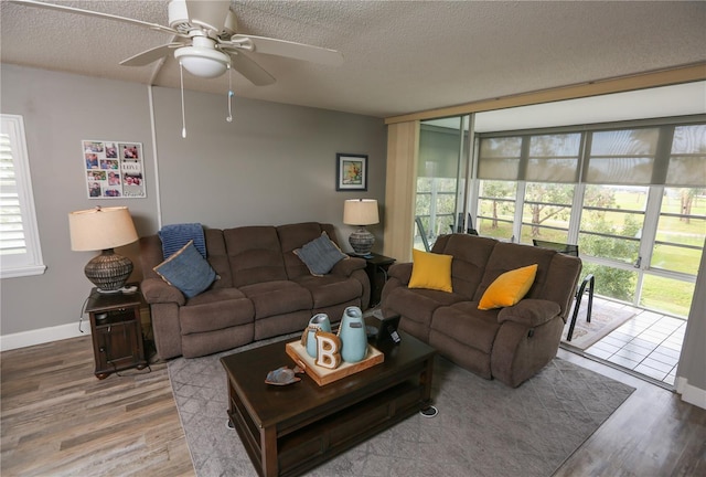 living room featuring hardwood / wood-style flooring, ceiling fan, and a textured ceiling