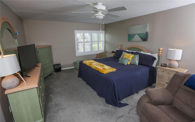 bedroom with ceiling fan, dark carpet, and a textured ceiling