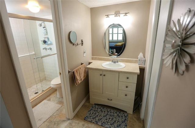 bathroom featuring vanity, toilet, and a shower with door