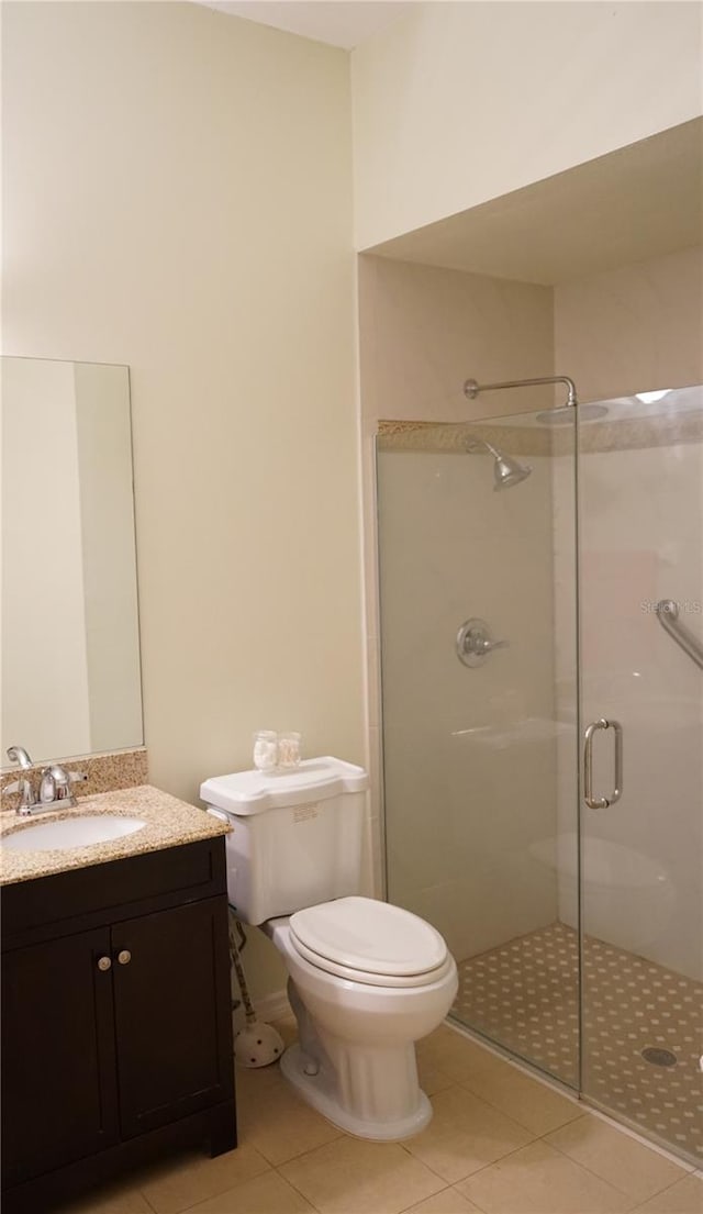 bathroom with tile patterned floors, vanity, toilet, and walk in shower