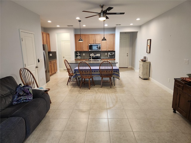 dining room with ceiling fan, light tile patterned floors, and sink