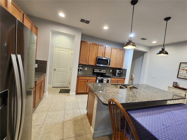 kitchen featuring stainless steel appliances, decorative backsplash, light tile patterned flooring, hanging light fixtures, and sink