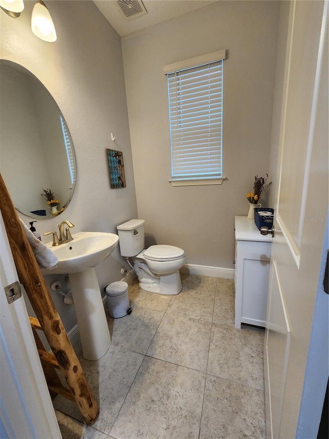 bathroom with sink, toilet, and tile patterned flooring