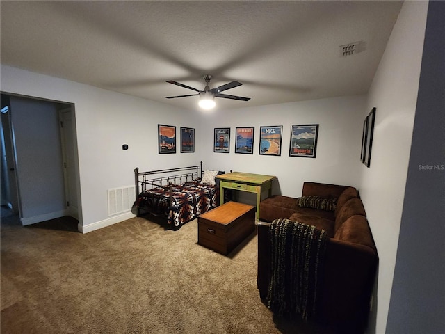 carpeted bedroom with ceiling fan and a textured ceiling