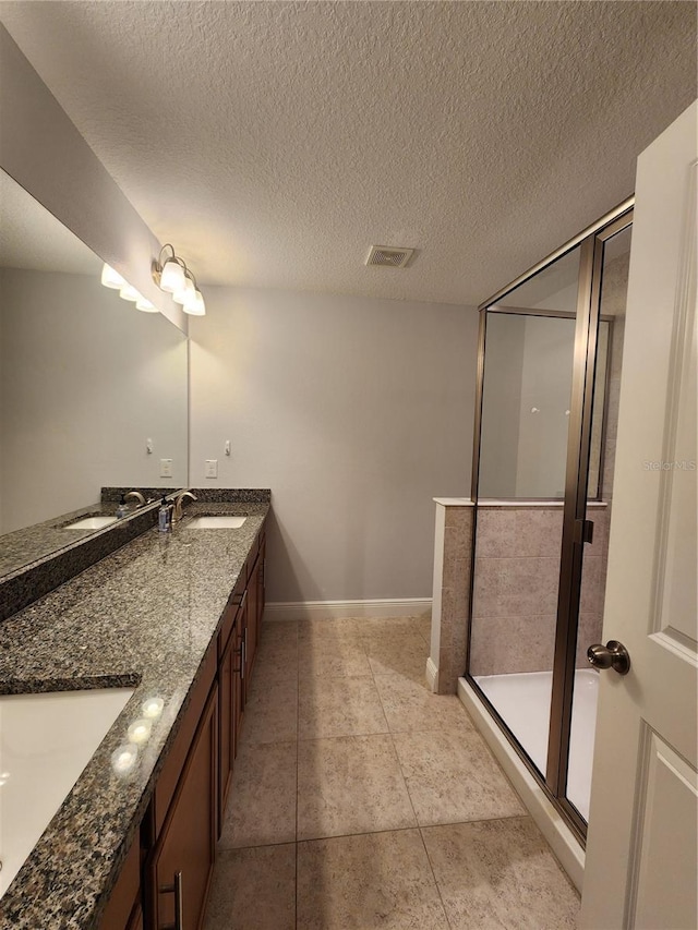 bathroom featuring a shower, a textured ceiling, tile patterned floors, and vanity