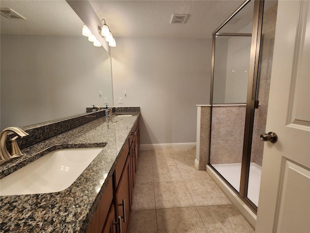 bathroom featuring walk in shower, vanity, tile patterned flooring, and a textured ceiling