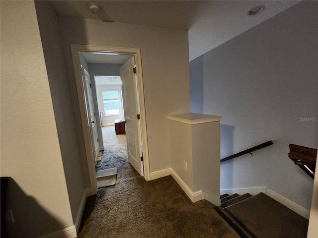 hallway featuring dark colored carpet