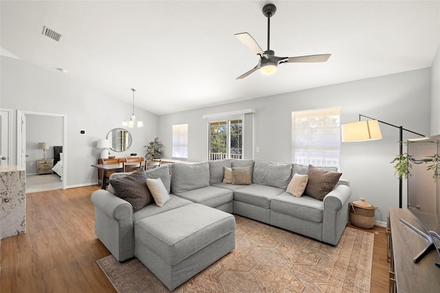 7001 Interbay Blvd Unit 313, Tampa, FL 33616 - living room featuring visible vents, light wood-type flooring, high vaulted ceiling, baseboards, and ceiling fan with notable chandelier