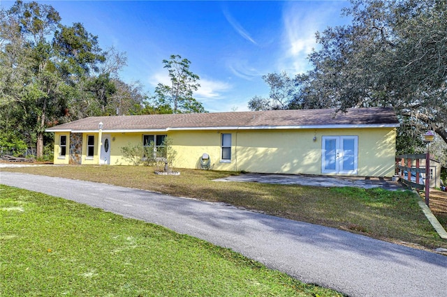 ranch-style house with french doors and a front lawn