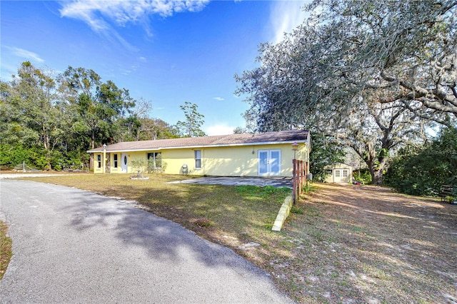 ranch-style house with a storage unit and a front yard