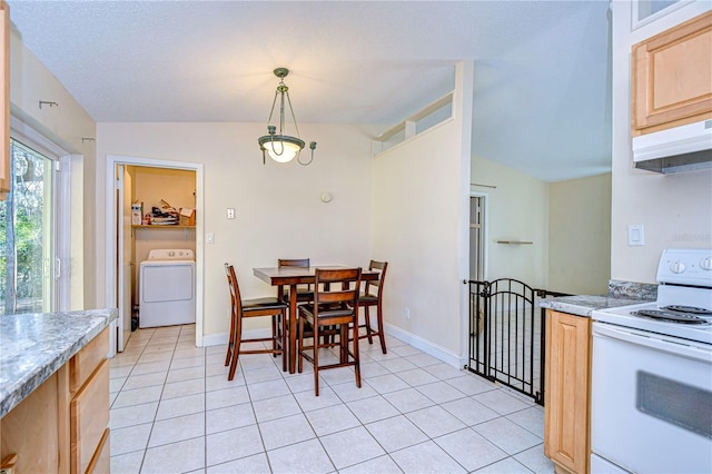 tiled dining space with washer / clothes dryer and lofted ceiling