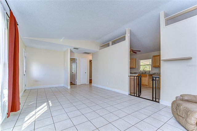 living room featuring lofted ceiling, a textured ceiling, and light tile patterned floors