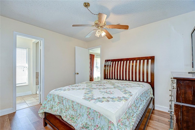 bedroom with ceiling fan, a textured ceiling, and light hardwood / wood-style flooring