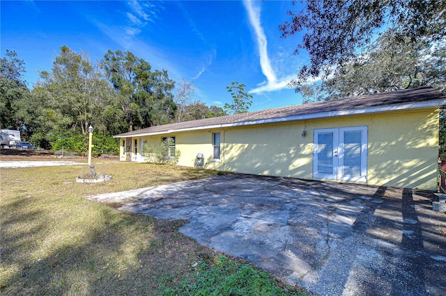 view of side of property with a yard and french doors