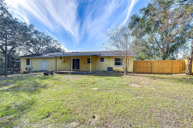 back of house featuring a lawn and central AC