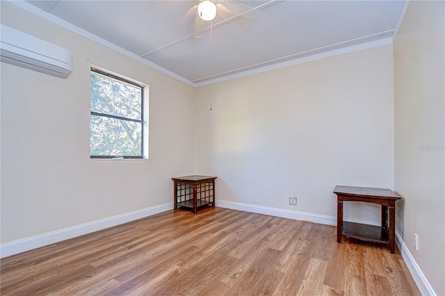 spare room featuring a wall mounted air conditioner, ornamental molding, baseboards, light wood-style flooring, and ceiling fan