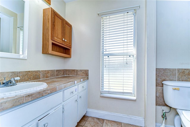 bathroom with toilet, vanity, tile patterned floors, and plenty of natural light