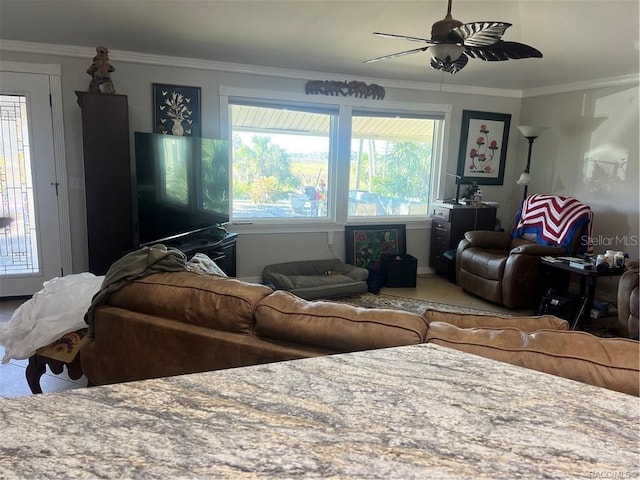 living room with plenty of natural light, ornamental molding, and ceiling fan