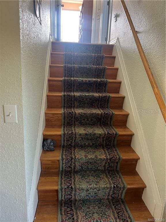 stairs featuring hardwood / wood-style floors