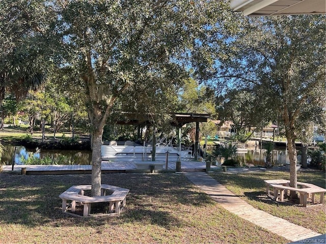 view of property's community with a water view and a lawn