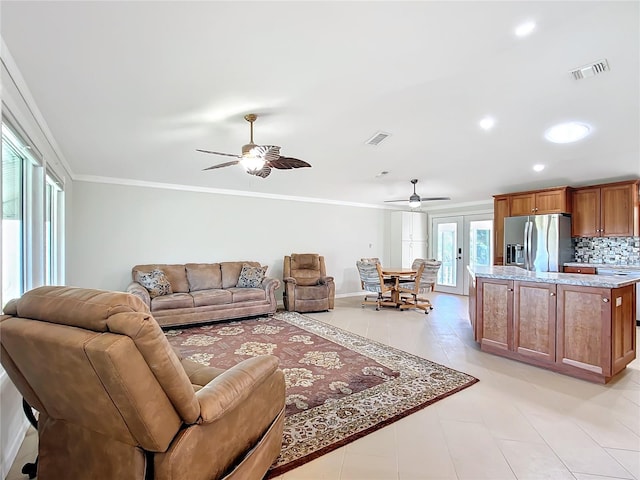 tiled living room with ceiling fan, french doors, and crown molding