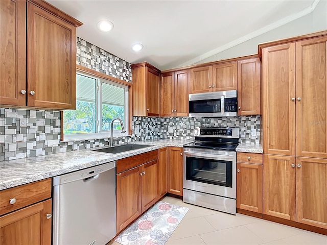 kitchen with appliances with stainless steel finishes, sink, backsplash, and lofted ceiling