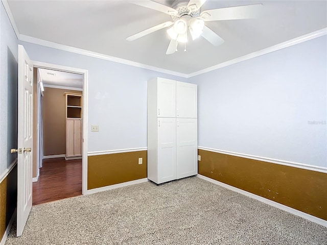 unfurnished bedroom featuring ceiling fan, ornamental molding, carpet flooring, and a closet