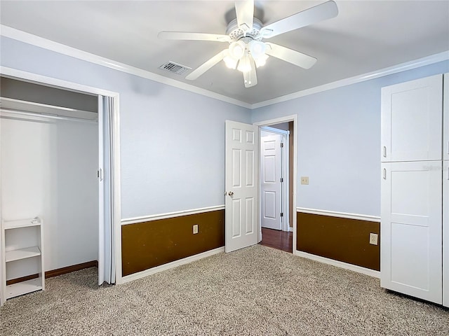 unfurnished bedroom featuring ceiling fan, ornamental molding, light carpet, and a closet