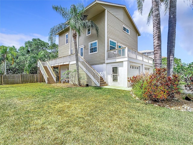 rear view of property featuring a yard, a balcony, and a garage