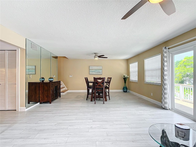 dining room featuring a textured ceiling, light hardwood / wood-style flooring, and ceiling fan