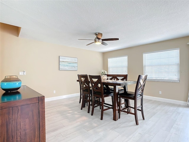 dining space with a textured ceiling, light hardwood / wood-style floors, and ceiling fan