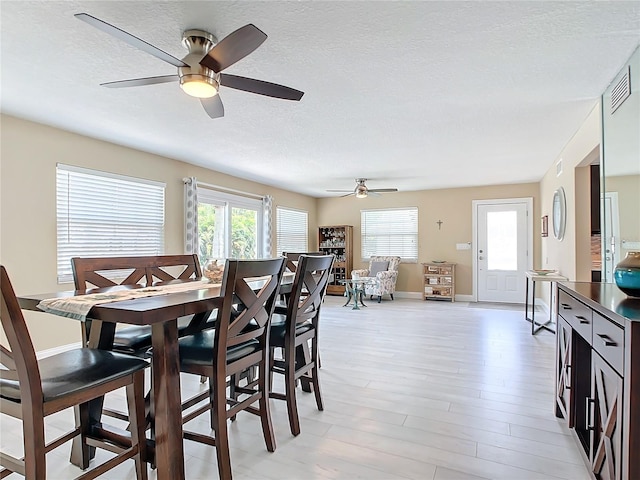 dining space with light hardwood / wood-style floors and ceiling fan