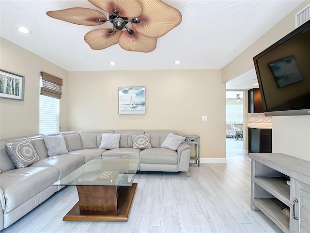 living room with ceiling fan and light wood-type flooring