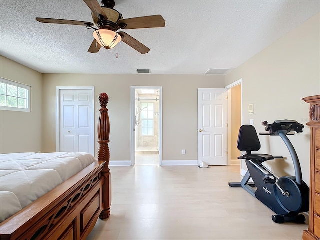 bedroom with a textured ceiling, a closet, ensuite bath, and ceiling fan