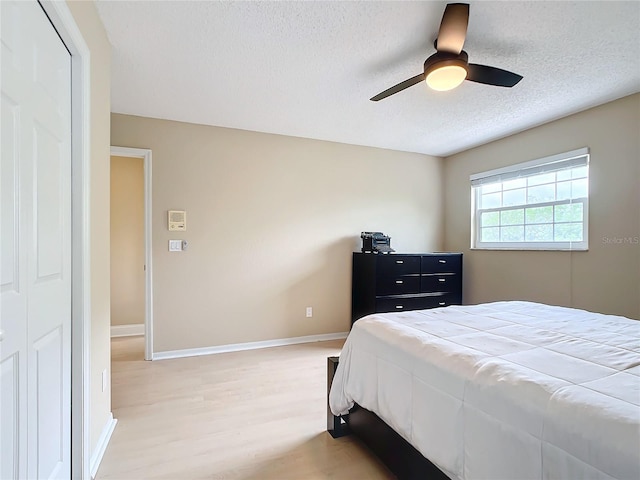 bedroom with a closet, hardwood / wood-style flooring, and ceiling fan