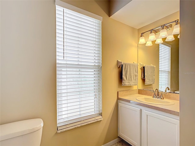 bathroom with vanity, toilet, and a healthy amount of sunlight