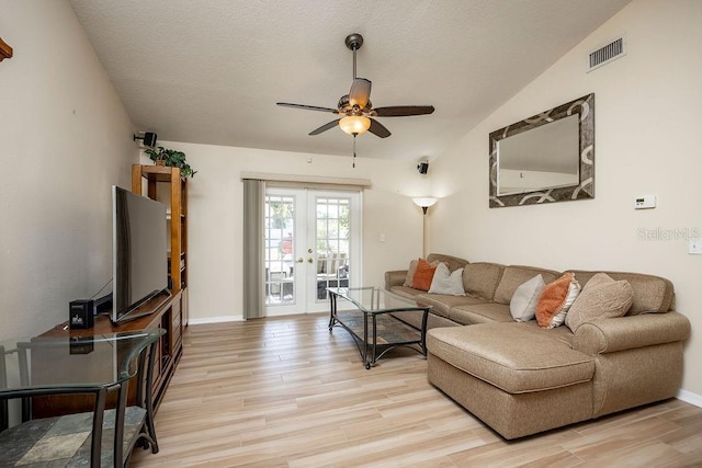 living room with ceiling fan, light hardwood / wood-style flooring, french doors, and vaulted ceiling