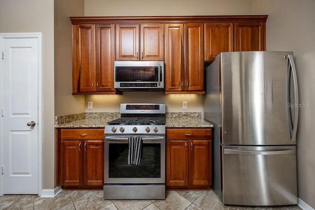 kitchen featuring stainless steel appliances and light stone counters