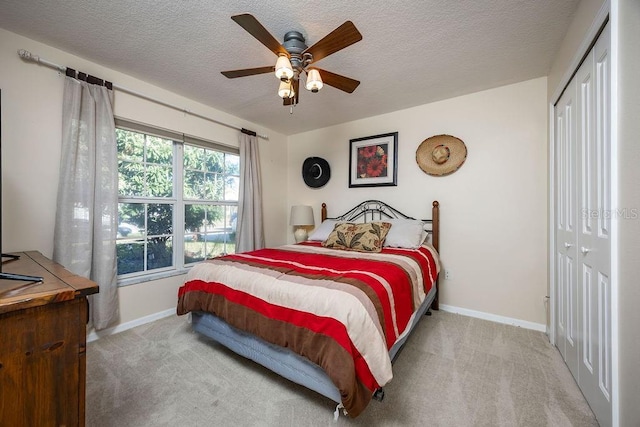 carpeted bedroom featuring a textured ceiling, ceiling fan, and a closet