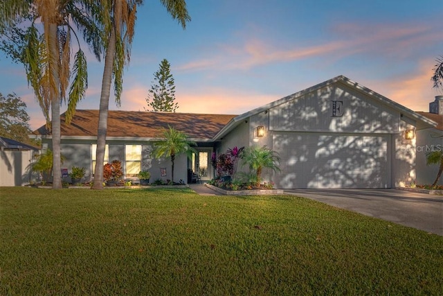 ranch-style house featuring a yard and a garage