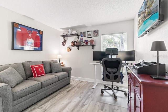 office area with light wood-type flooring and a textured ceiling