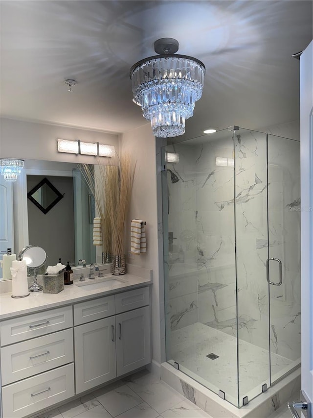 bathroom with vanity, a notable chandelier, and a shower with shower door