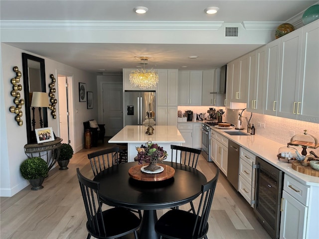 kitchen featuring wine cooler, white cabinetry, a center island, and appliances with stainless steel finishes