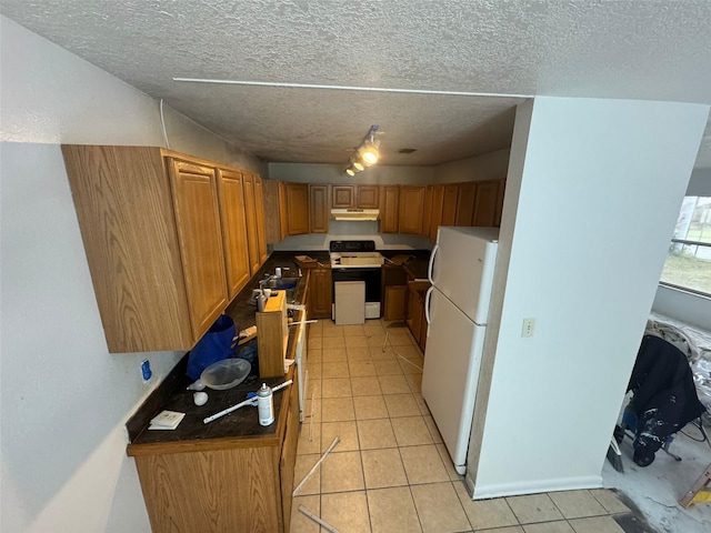 kitchen featuring white refrigerator, a textured ceiling, and electric range oven