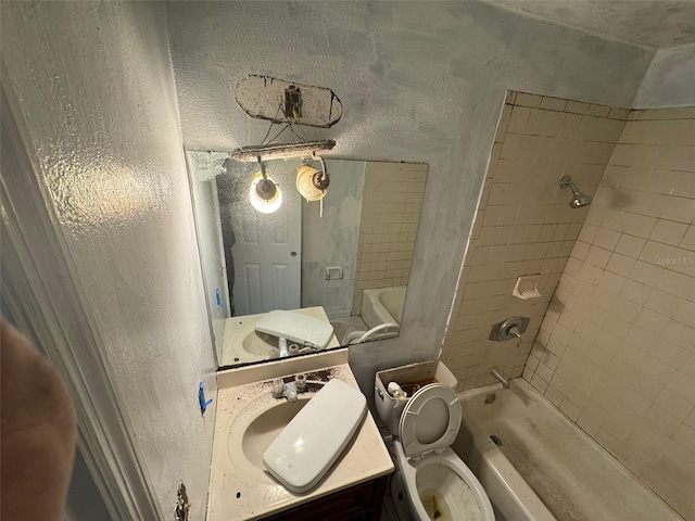 full bathroom featuring tiled shower / bath combo, toilet, and vanity