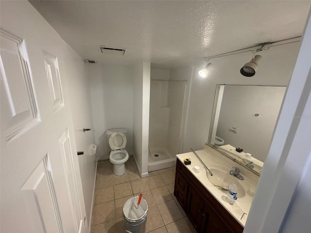 bathroom with a shower, tile patterned flooring, toilet, a textured ceiling, and vanity