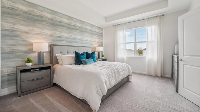 carpeted bedroom featuring a raised ceiling