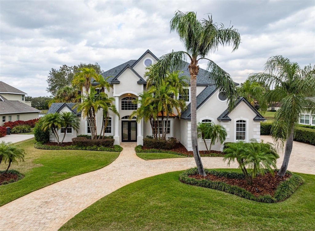 view of front of home with french doors and a front lawn