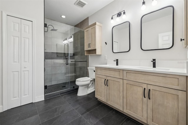 bathroom with tile patterned floors, vanity, toilet, and a shower with door